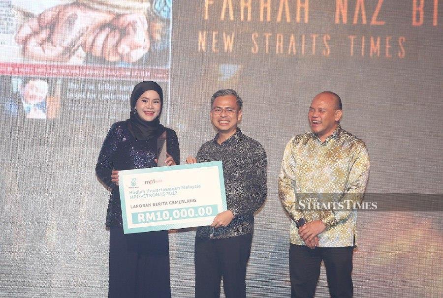Communications and Digital Minister Fahmi Fadzil (centre) presents the Excellent News Reporting award to New Straits Times group editor Farrah Naz Karim (left). Looking on is Harian Metro group editor Husain Jahit. - NSTP/SAIFULLIZAN TAMADI