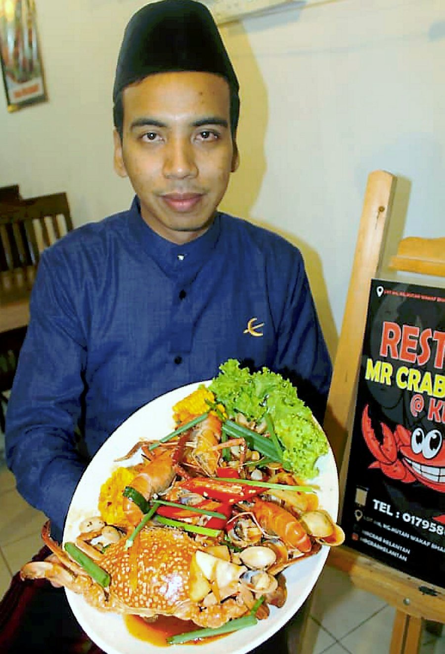 Aiman Yusri Mohd Yusof showing one of the crab dishes available at his restaurant. Pix by Sharifah Mahsinah Abdullah