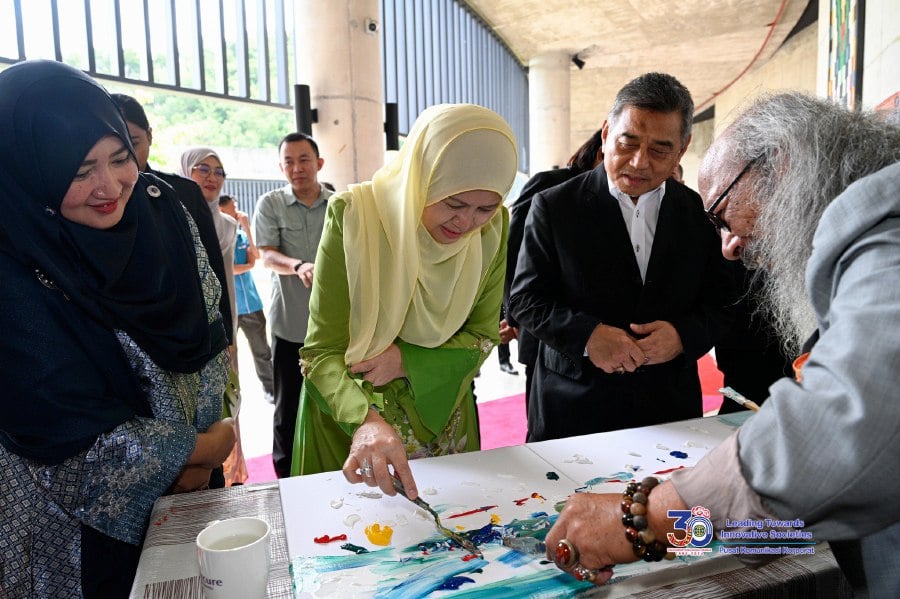 Toh Puan Norlidah R.M. Jasni during the launching of mushroom exhibition produced by local photographers and artists. Also in attendance was Vice Chancellor Prof Datuk Dr Kasim Mansor (right). -- Pic courtesy of UMS