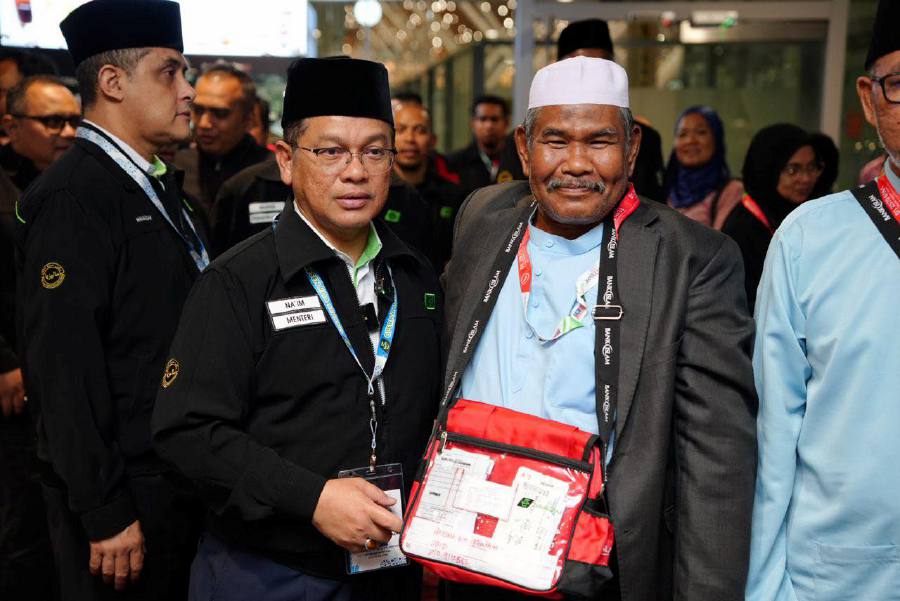 Datuk Dr Mohd Na’im Mokhtar (left) with pilgrims at Kuala Lumpur International Airport (KLIA). - Pic credit Facebook/DatoSetiaDr.Naim