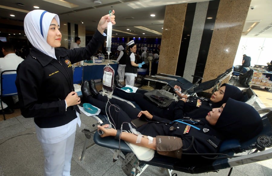 KUALA LUMPUR: Police officers donating blood during the blood donation programme in conjunction with the 217th Police Day celebration at Bukit Aman, Kuala Lumpur. -NSTP/HAIRUL ANUAR RAHIM