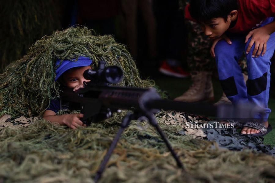 KUALA LUMPUR: A young visitor taking the opportunity to hold a firearm at the Malaysia Armed Forces exhibition booth at the Madani government's One-Year Anniversary Programme in Bukit Jalil National Stadium. - BERNAMA PIC