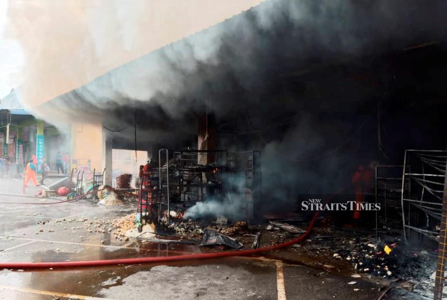 Firemen at the scene in Nilai 3 Industrial Zone, which saw nine shops damaged and a woman injured. -NSTP/Courtesy of Fire and Rescue Dept.