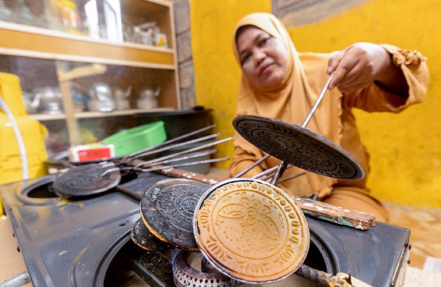  TUMPAT: Noriah Ramli, 47, preparing the kuih kapit (Love Letter) at her home in Kampung Pulau Suri. -- BERNAMA PIC