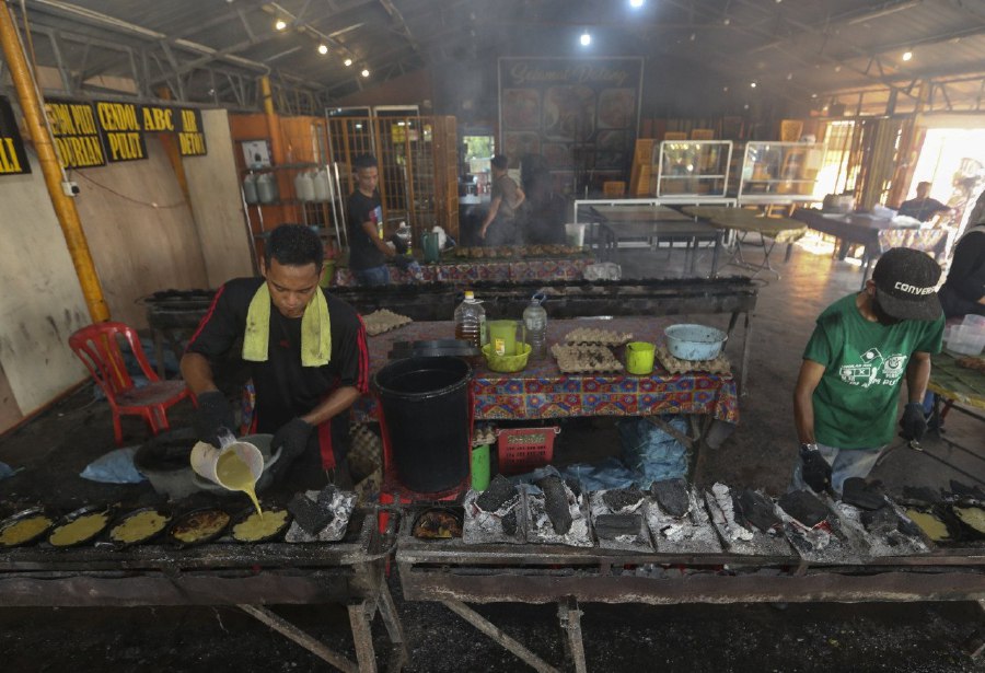 PASIR MAS: A worker preparing the kuih akok at a shop along Jalan Pasir Mas-Rantau Panjang. -- NSTP/NIK ABDULLAH NIK OMAR