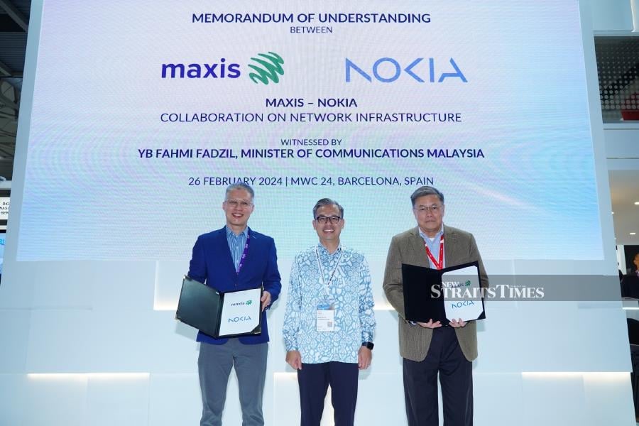 (Center) YB Fahmi Fadzil, Malaysian Minister of Communications with (left) Ngiam Ming Kin , Head of South Asia Network Infrastructure, Nokia and (right) Goh Seow Eng , Chief Executive Officer of Maxis at the Memorandum of Understanding (MoU) ceremony held at the Pavilion Malaysia in conjunction with Mobile World Congress 2024 in Barcelona, Spain.