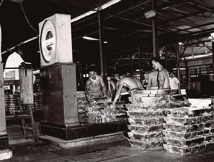 Workers weighing tin ingots at the Eastern Smelting Company depot.