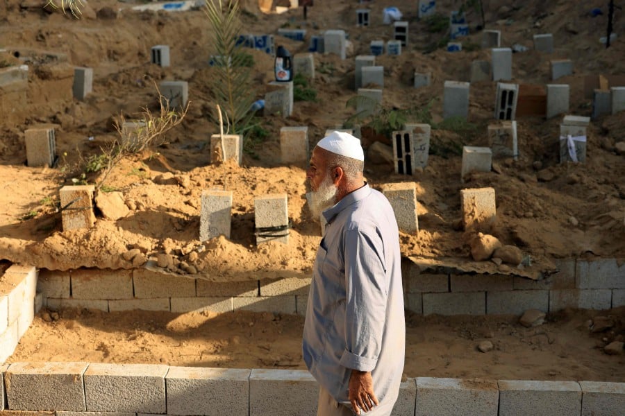 Palestinian grave digger 63-years-old Sadi Barka, walks past breeze blocks used to mark graves at the Deir el-Balah cemetery, in the central Gaza Strip on November 10, 2023, amid the ongoing battles between Israel and the Palestinian Islamist group Hamas. AFP PIC