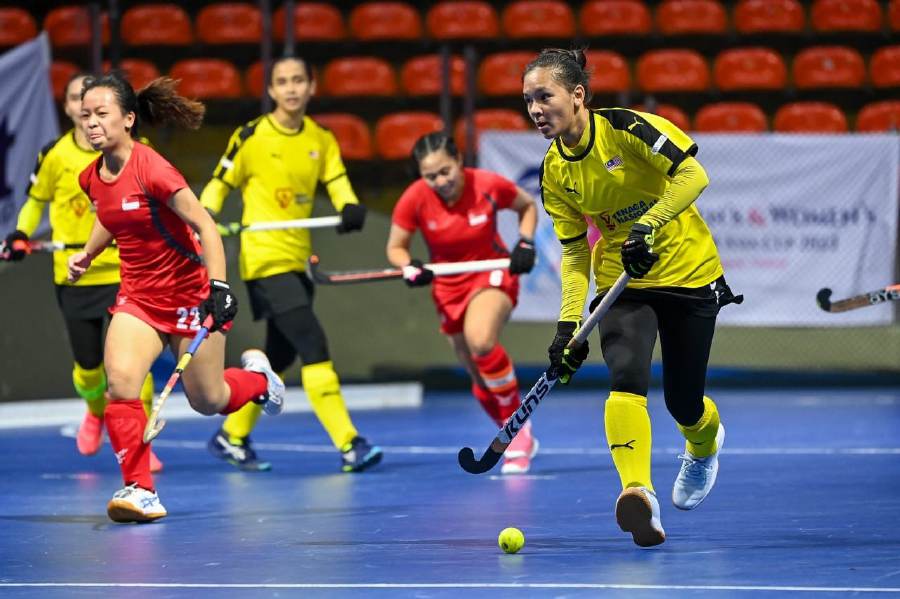The Malaysian women's team (in yellow) in action against Singapore in the Asia Cup indoor hockey tournament in Bangkok today.