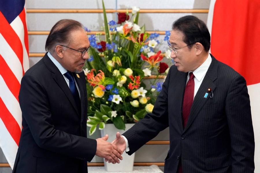 Japan's Prime Minister Fumio Kishida (R) shakes hands with Malaysia's Prime Minister Datuk Seri Anwar Ibrahim at the start of their meeting at the prime minister's official residence in Tokyo. - AFP PIC