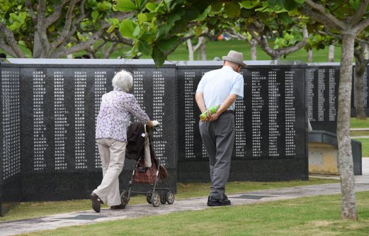  An elderly couple walks beside a monument commemorating more than 240,000 people including US soldiers who died in the battle of Okinawa during World War II at the Peace Memorial Park in Itoman, Okinawa prefecture, on June 19, 2015. The battle claimed the lives of more than 100,000 Okinawan civilians and 80,000 Japanese troops, whose grim resistance only ended after Lieutenant General Mitsuru Ushijima, the senior officer on the island, committed ritual suicide on a cliff.  AFP PHOTO 