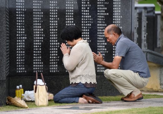 People pray in front of the monument commemorating those who died in the battle of Okinawa during World War II at the Peace Memorial Park in Itoman, Japan's southern inlands prefecture Okinawa, on June 20, 2015. Japan will mark the 70th anniversary of the end of the battle of Okinawa on June 23. AFP PHOTO 