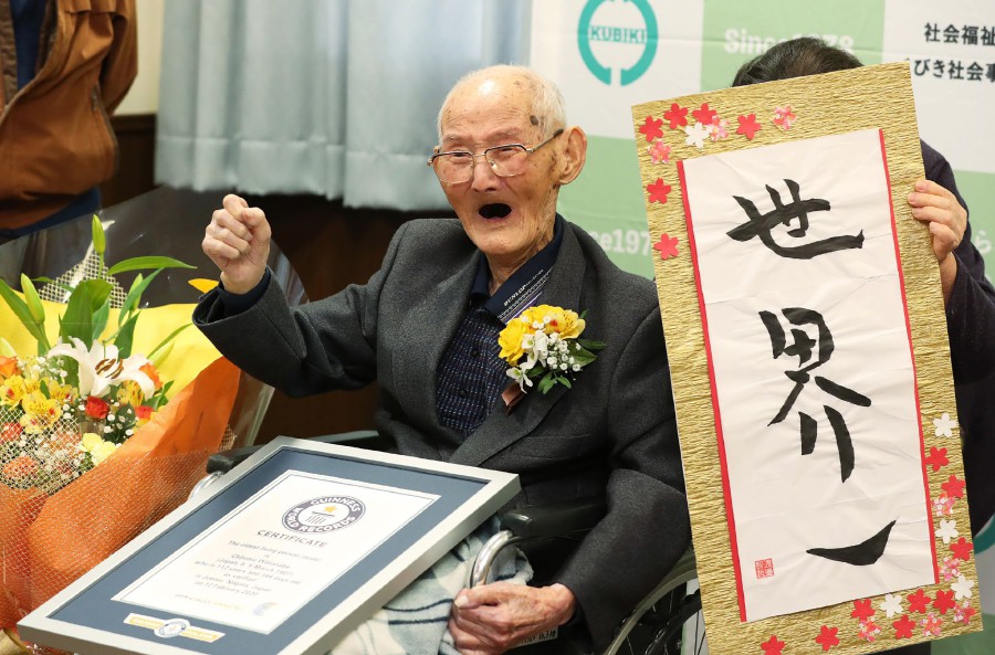 Chitetsu Watanabe poses next to calligraphy reading in Japanese 'World Number One' after he was awarded as the world's oldest living male in Joetsu, Niigata prefecture. JAPAN POOL/JIJI PRESS/AFP pic