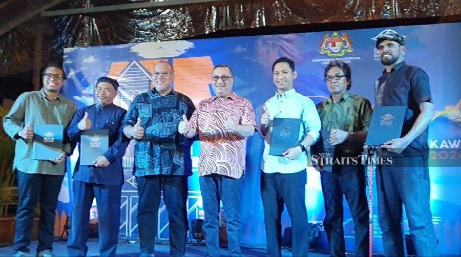 Shaik Rizal Sulaiman (middle) accompanied by Amerrudin Ahmad (third from left) together with recipients of the Arts Aid Fund grants in conjunction with the reopening of the Langkawi National Art Gallery in Langkawi. (NSTP/HAMZAH OSMAN)