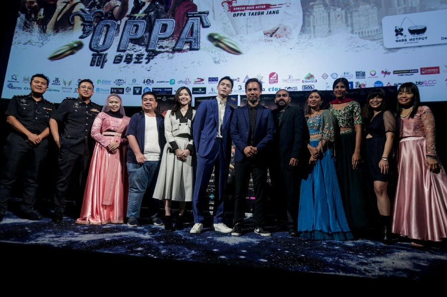 Director Denil Choon Lin Loong (sixth from right) with the cast of ‘Oppa’, a film that aims to spread awareness on love scams. - Pic by HAZREEN MOHAMAD