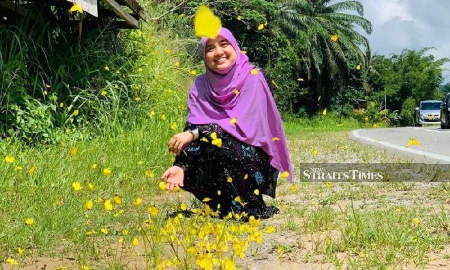  Nurul Asna Hidayah taking picture during the unusual phenomenon whereby thousands of yellow butterflies are seen flying along Kota Marudu road. - Pic by Nurul Asna Hidayah.