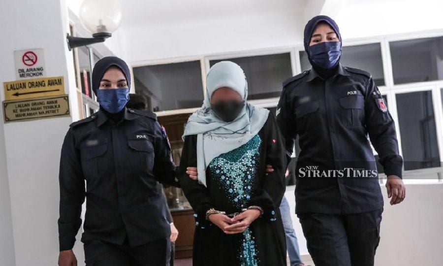 Policewomen escort the suspect at the Selayang Sessions Court ahead of the hearing. - NSTP/HAZREEN MOHAMAD