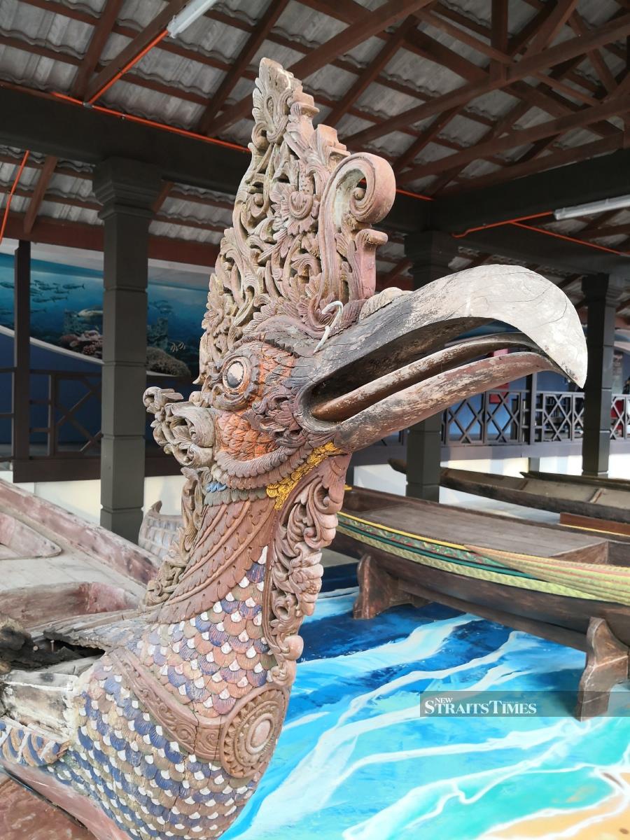 Intricately carved boats form the outdoor exhibits.