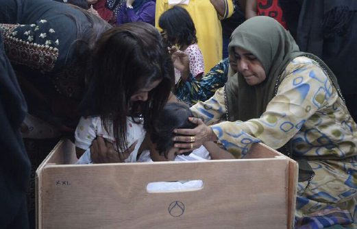 Family members pay their last respects to the driver and his daughter who where killed in the Pagoh bus crash. Pix by SHAHNAZ FAZLIE SHAHRIZAL. 