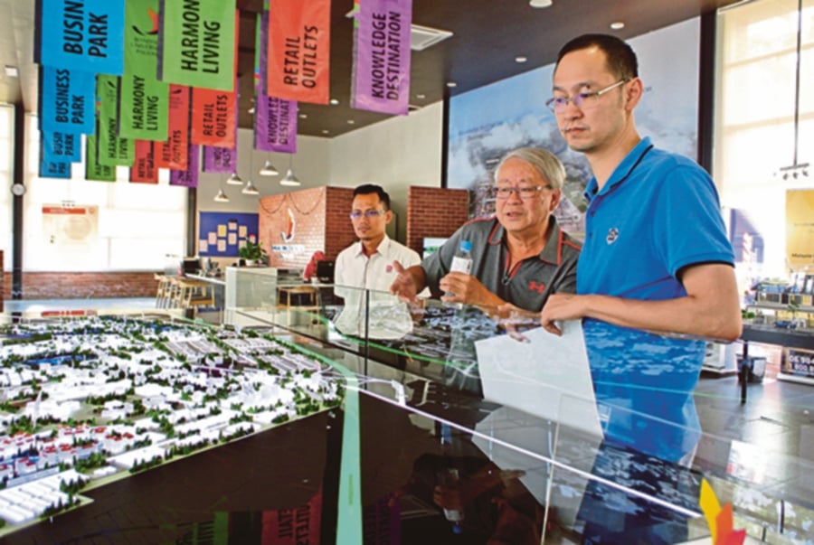 Visitors taking a closer look at a scale model of Bandar Universiti Pagoh.