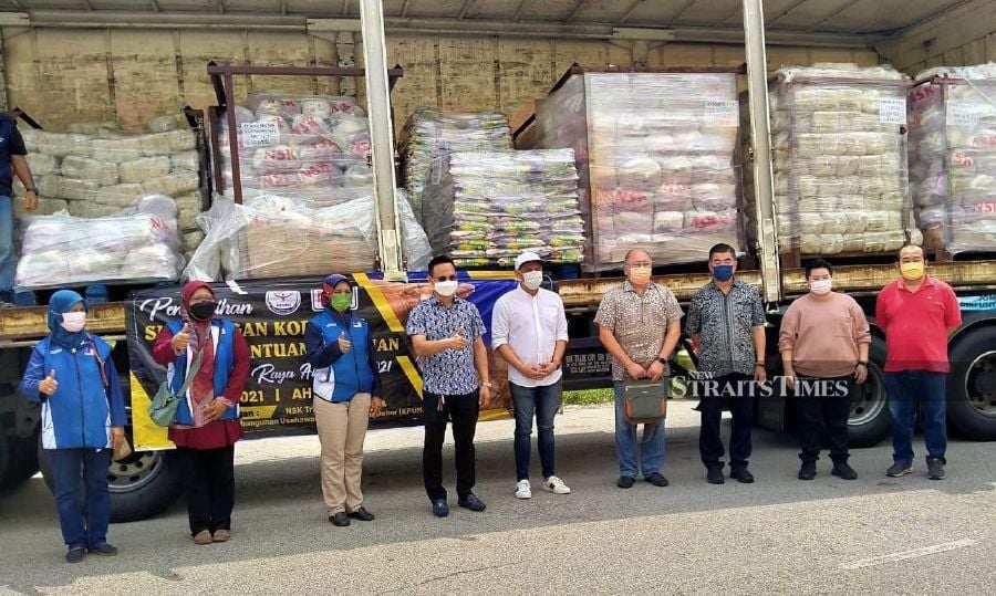 Muhammad Shamsuddin Paijan (fourth from left) receiving supplies from Kenny Chen (sixth from left) and the NSK management team. - NSTP/ZAINAL AZIZ