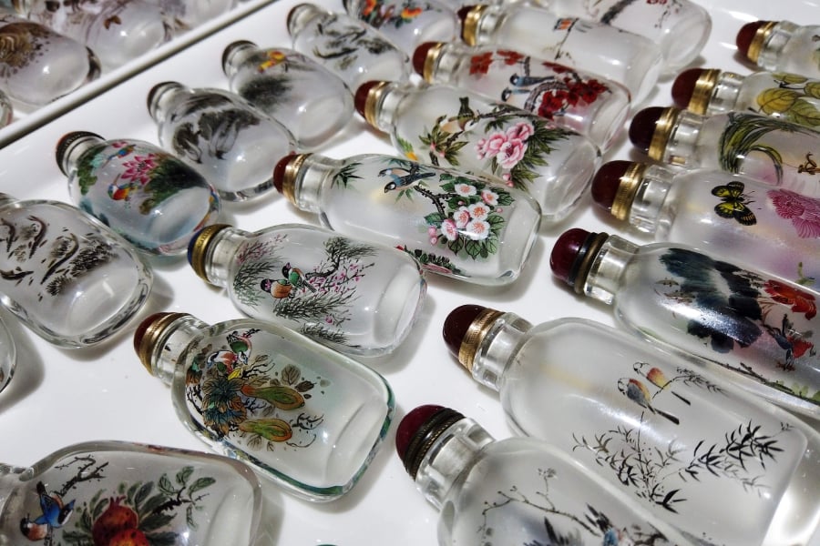 This picture taken on July 12, 2019 shows snuff bottles painted by artists by hand at a shop in the centre of Beijing. (Photo by Leo RAMIREZ / AFP) 