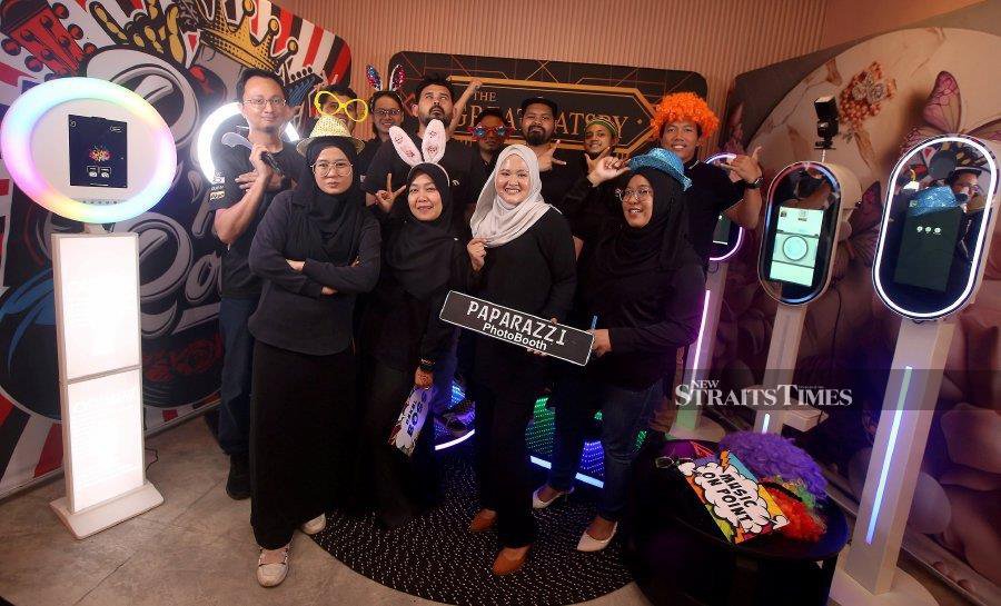 Paparazzi Photo Booth founder Nursyelina Aluwi (second from right) and her employees posing at their artificial intelligence-powered photo booth recently.