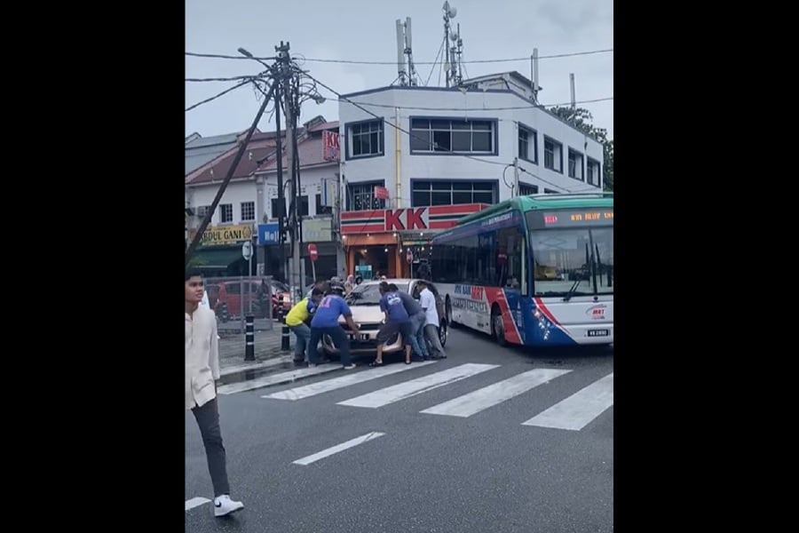 An irresponsible driver parking at a road curve not only led to a significant traffic jam but also inconvenienced a group of Good Samaritans, who had to lift and move a car. - Pic from Facebook ‘Komuniti Bandar Tasik Selatan – Sungai Besi’ 