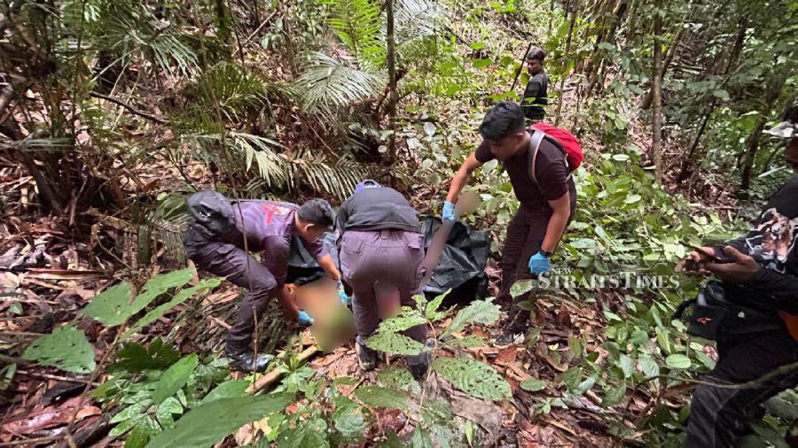 Rescuers carry the remains of the victim found at Kuala Wok near Pos Pasik. - Pic courtesy of police