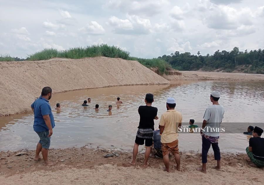 A 17-year-old youth drowned while swimming in a sand mine near Kampung Bagan in Machang yesterday. Pic courtesy of PDRM.