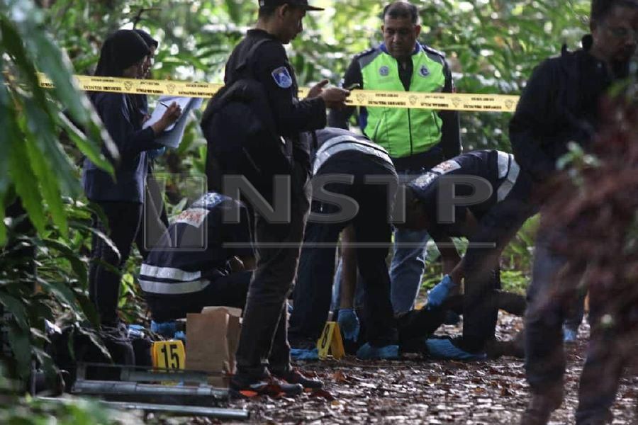 Forensic officers at the scene where three parang-wielding men were shot dead by police at Puncak Bukit Mutiara, Tanjong Bungah. - NSTP/MIKAIL ONG