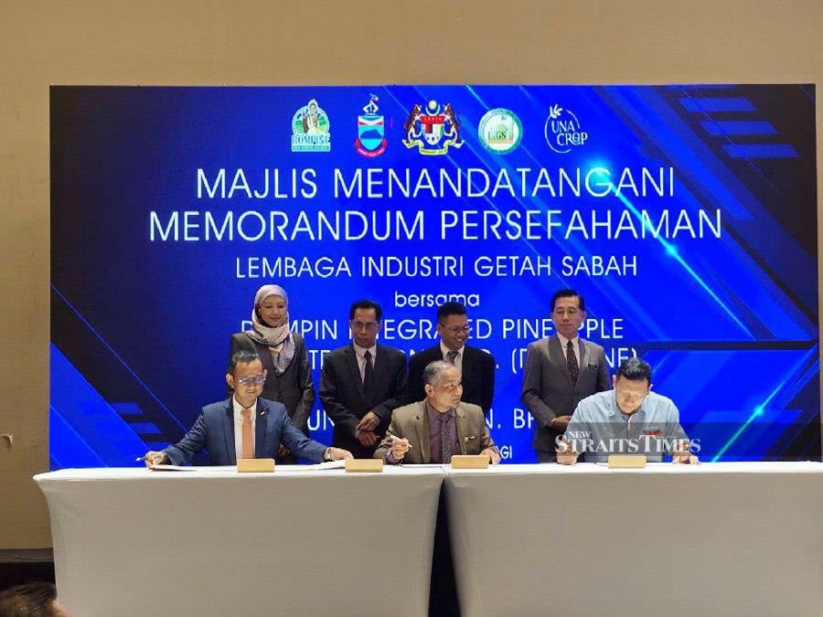 Sabah Assistant Agriculture, Fisheries and Food Industry minister Peto Galim (standing second right) witnessing the Memorandum of Understanding signing at Sabah International Convention Centre here. - NST/OLIVIA MIWIL