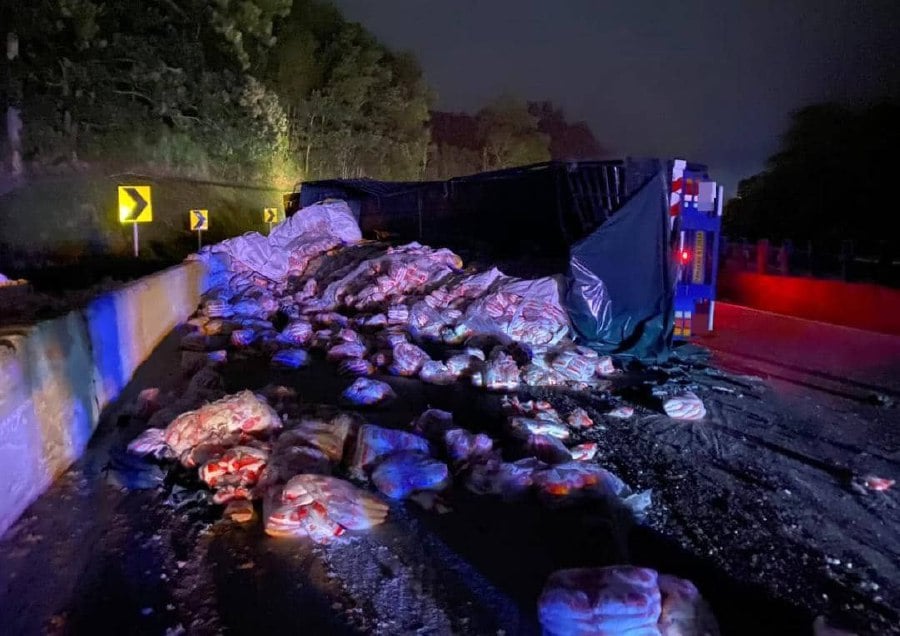 The trailer lorry with some of the refined sugar packets strewn across the road at KM4 of the Kuala Lumpur - Karak Highway. -- Pic courtesy of police