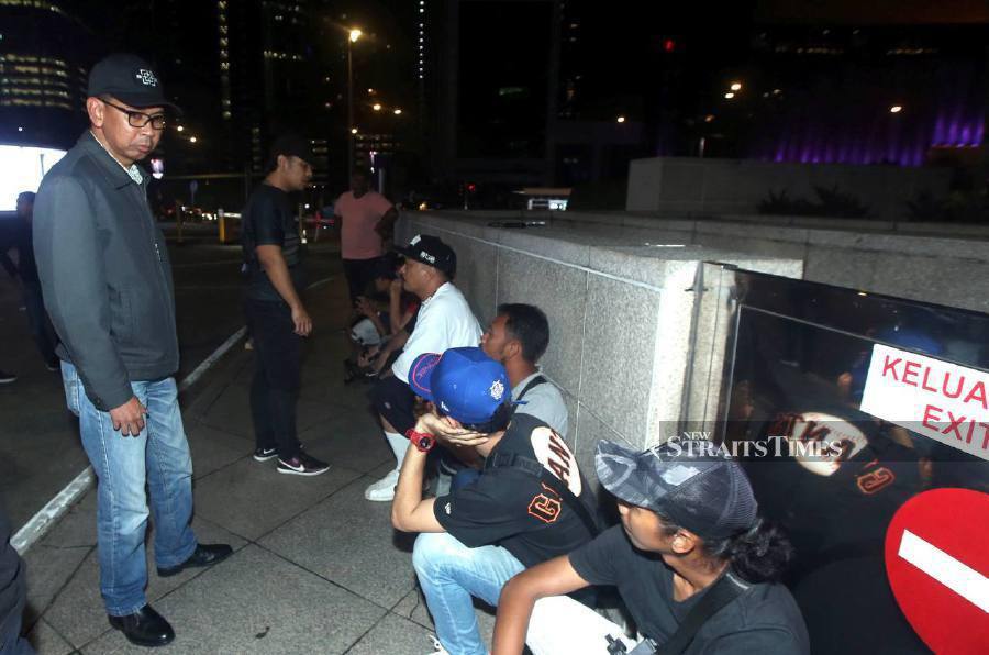 Immigration Department deputy director-general Jafri Embok Taha (left) questioning some of the suspected illegal immigrants near KLCC area. -- NSTP/HAIRUL ANUAR RAHIM