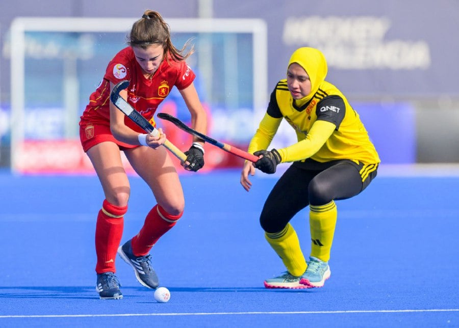 Malaysia (right) and Spain in action in Saturday's Olympic qualifying match in Valencia. -- PIC FROM FIH