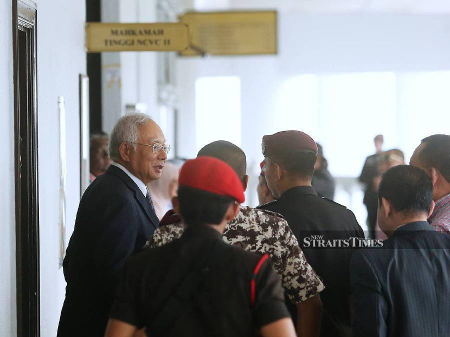Former prime minister Datuk Seri Najib Razak being escorted outside the court this morning. -- NSTP/SAIFULLIZAN TAMADI