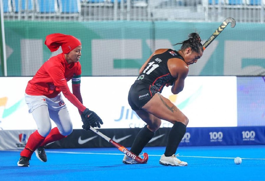 A Malaysia player (in red) tries to stop an attempt from a New Zealand player in the women's Hockey 5s World Cup in Muscat, Oman. - Courtesy pic