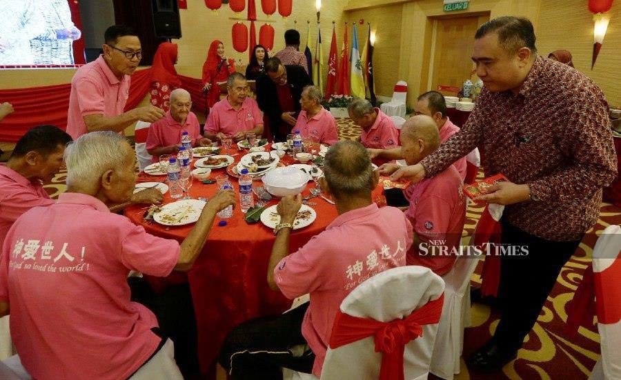 Transport Minister Anthony Loke handing out angpows to elderly people during Majlis Sua Kasih MADANI and the ministry’s monthly assembly in Putrajaya. -- NSTP/MOHD FADLI HAMZAH