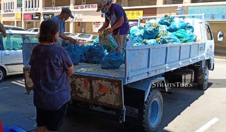 A hawker stall owner gave away almost 2 tonnes of vegetables to city folk here on Saturday. - NSTP/ Courtesy of NST reader