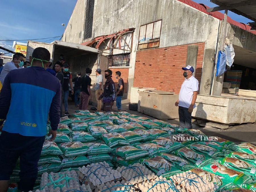 Kalabakan Member of Parliament Ma’mun Sulaiman (with black mask) distributing food supply to constituents affected by MCO. - NSTP/MA’MUN SULAIMAN