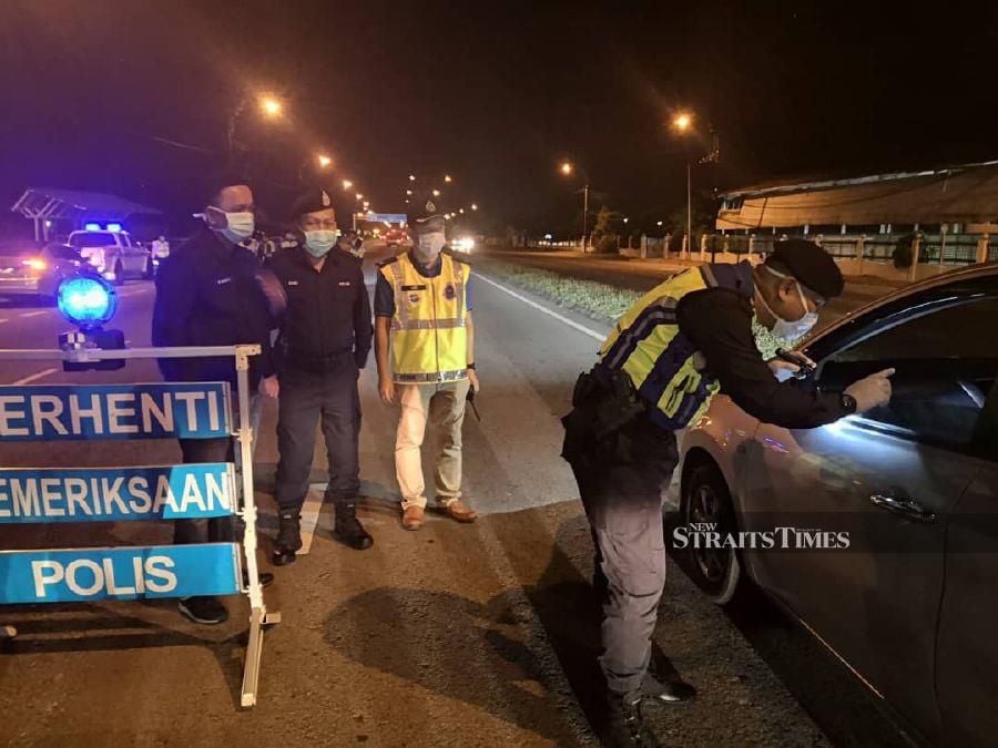 Sabah police conducting a roadblock along Jalan Kepayan last night to remind motorists of the Control Movement Order. - NSTP/Olivia Miwil