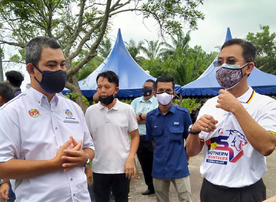 Sahruddin (right) congratulates Mustaffa on achieving the highest inoculation among all districts in Johor. - NSTP/Zainal Aziz