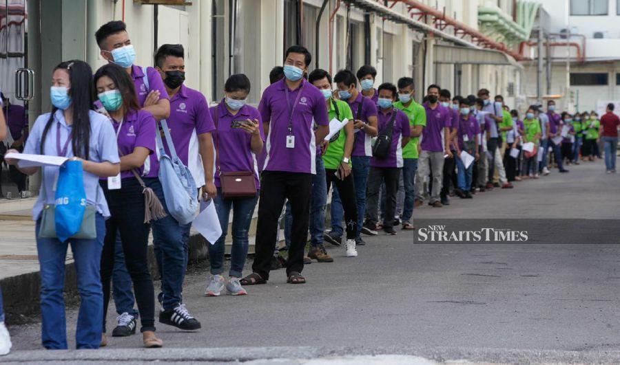 Workers waiting to have their Covid-19 test done in Bayan Lepas. - NSTP/DANIAL SAAD