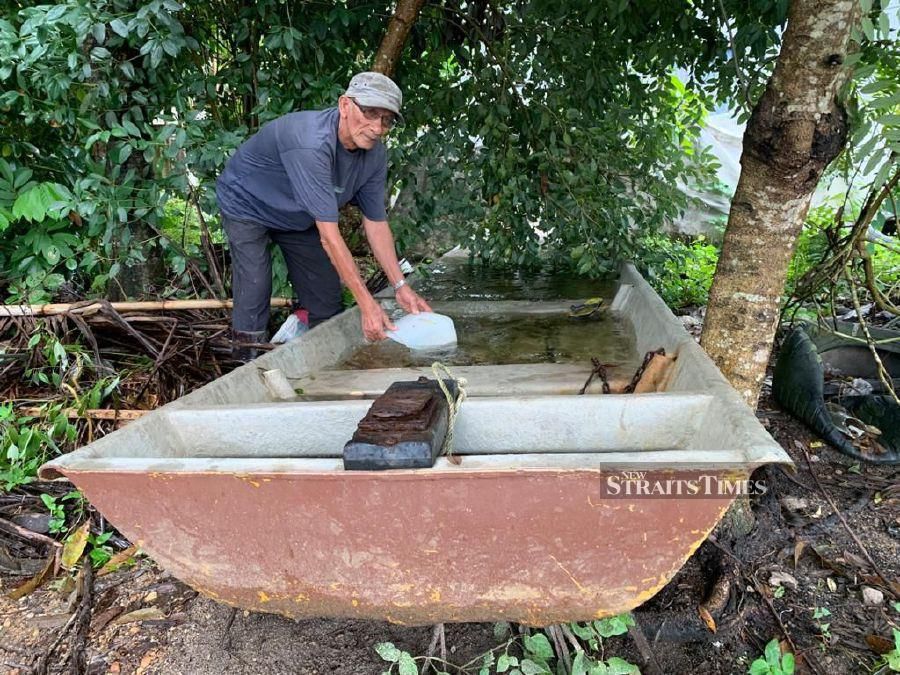 Mohamad Nor Awang cleaning his boat in preparation of the monsoon season. -NSTP/Sharifah Mahsinah Abdullah