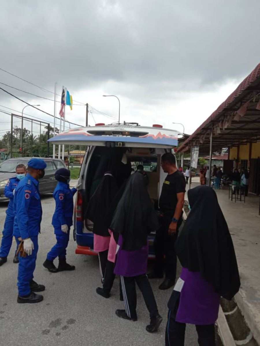 Civil Defence personnel help students to get into an ambulance. - Pic courtesy of Civil Defence Force. 