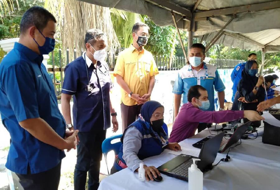 Mohd Badri (second from right) supervising vaccine registration for the Orang Asli community in Kg Sentosa. - NSTP/ Aziz Zainal Aziz 