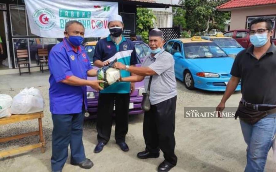 Bukit Pasir assemblyman Najib Lep (second from left) handing over aid to taxi drivers. - NSTP/ZAINAL AZIZ