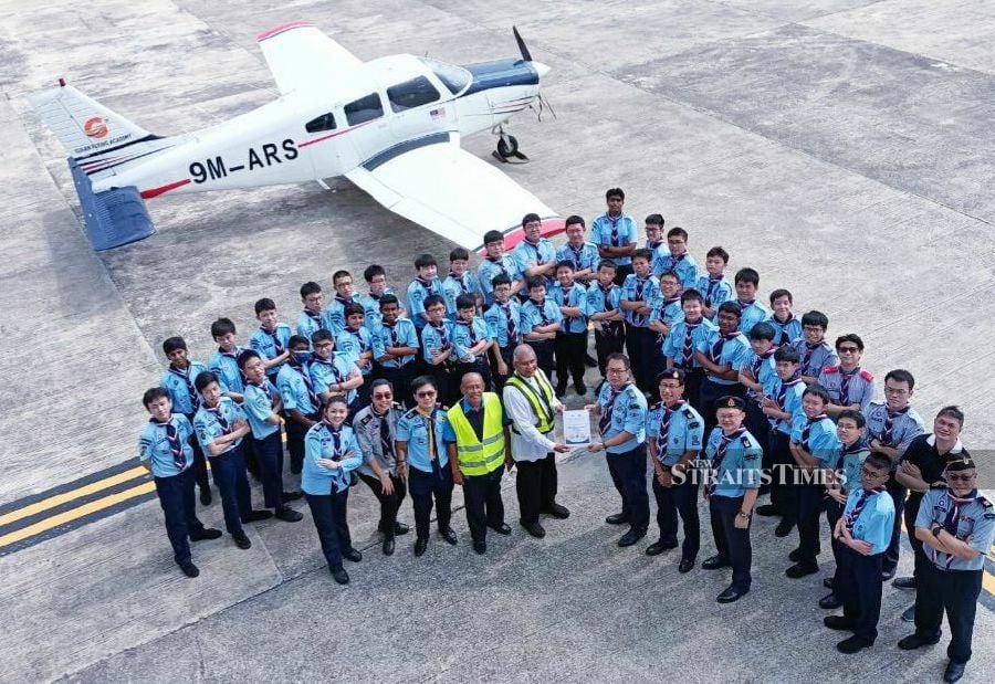 Datuk Sirajudin Mohamed Mydin (front row, fifth from left) handing over the Airscout Honor batch and certificates to the Bukit Bintang district scouts at the Giaan Flying Academy at the Skypark Regional Aviation Centre (RAC), Sultan Abdul Aziz Shah Airport, Subang in Selangor. - Courtesy pic