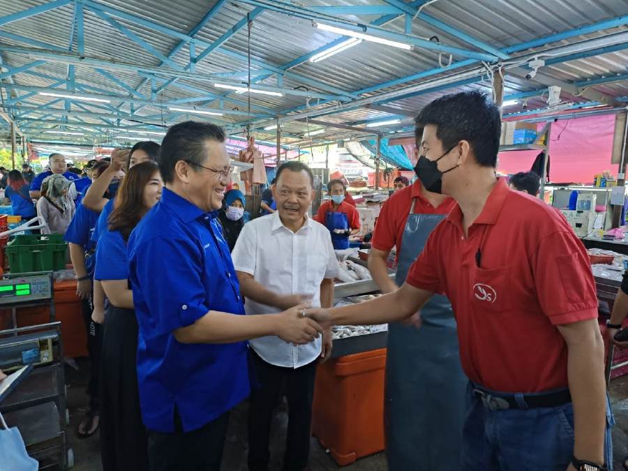 Datuk Nur Jazlan (left) greeting patrons during a walk-about at a wet market in the Pulai constituency. - Pic courtesy of Nur Jazlan.