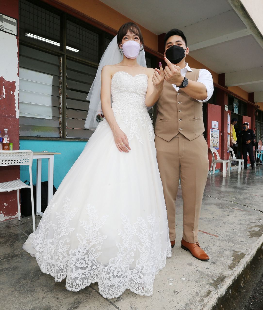 The presence of Lee Choy Yoong and her groom Jackie Har, 30, both 30, at the SK Taman Muda polling centre turned heads as they arrived in their wedding outfits. - NSTP/SAIFULLIZAN TAMADI